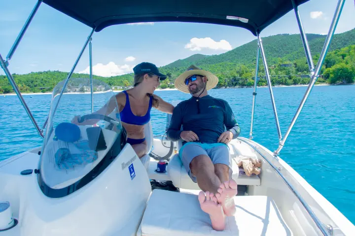 a man and a woman sitting on a boat in the water