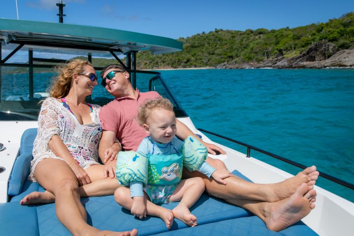 a man and woman sitting next to a body of water