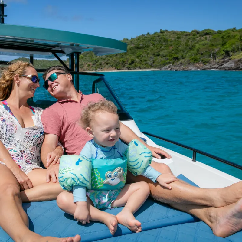 a man and woman sitting next to a body of water