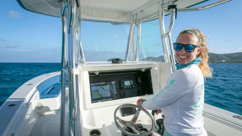 a woman standing on a boat in the water