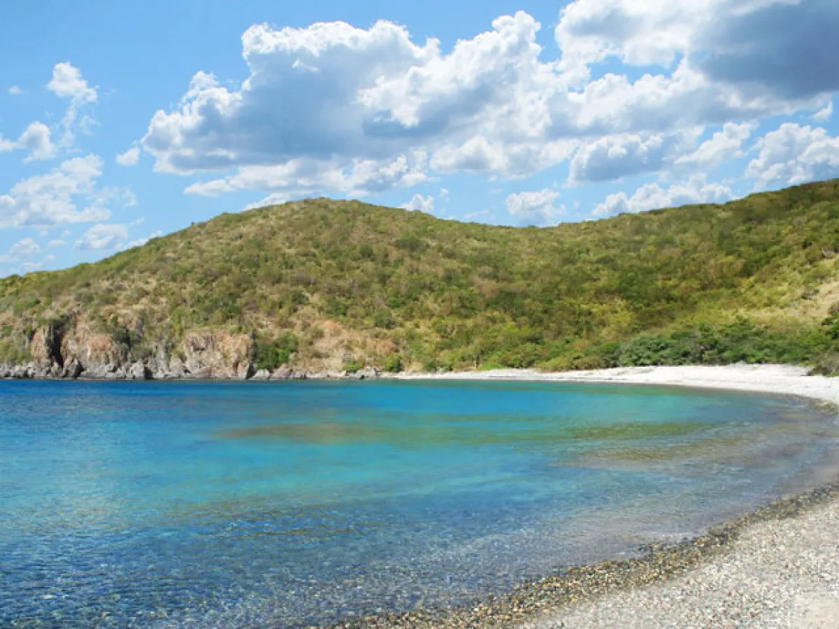 a sandy beach next to a body of water