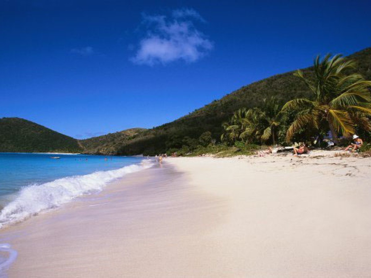 a sandy beach next to a body of water