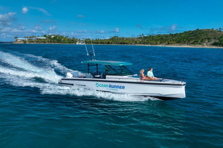A speedboat labeled 'Ocean Runner' cruises on blue water with an island backdrop.