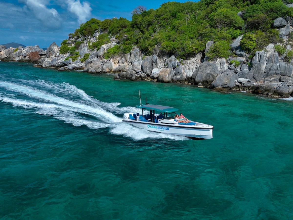 a small boat in a body of water with a mountain in the background