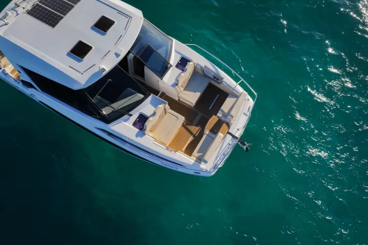 Overhead view of a white boat in clear turquoise water.