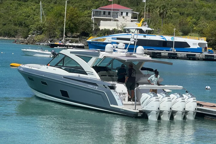 Motorboat docked with people aboard near waterfront buildings.